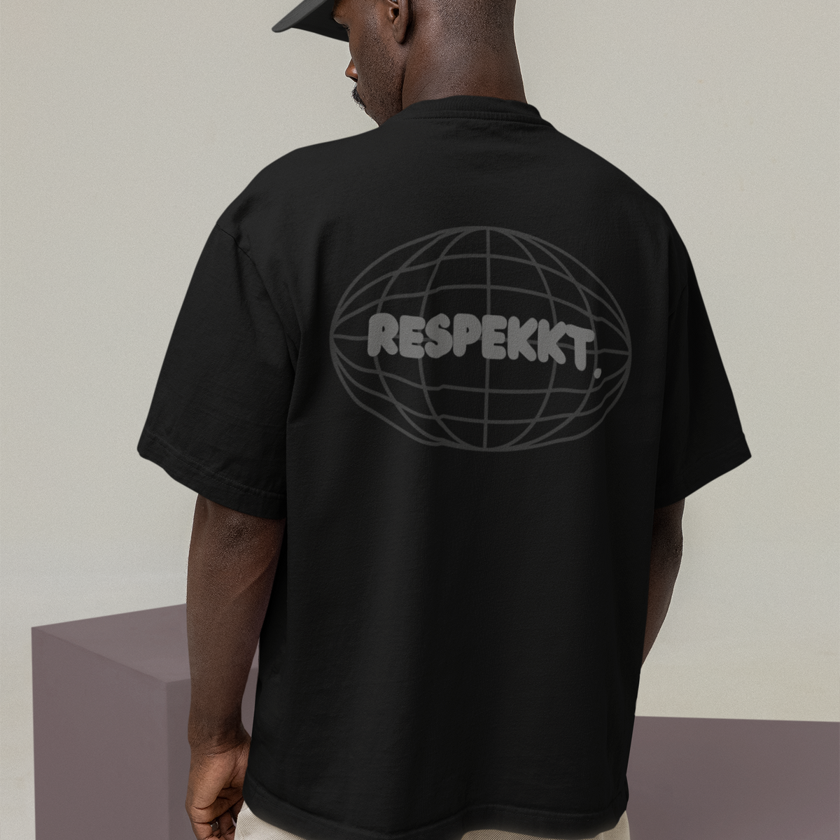 Mann mit schwarzem Oversized T-Shirt auf dem das Logo von der Marke Respekkt. aufgedruckt ist.
