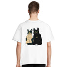 Person mit einem weißen, oversized T-Shirt mit einem Rückaufdruck, auf dem zwei gemalte Katzen zu sehen sind sowie der Spruch: "Adopt, don't shop."