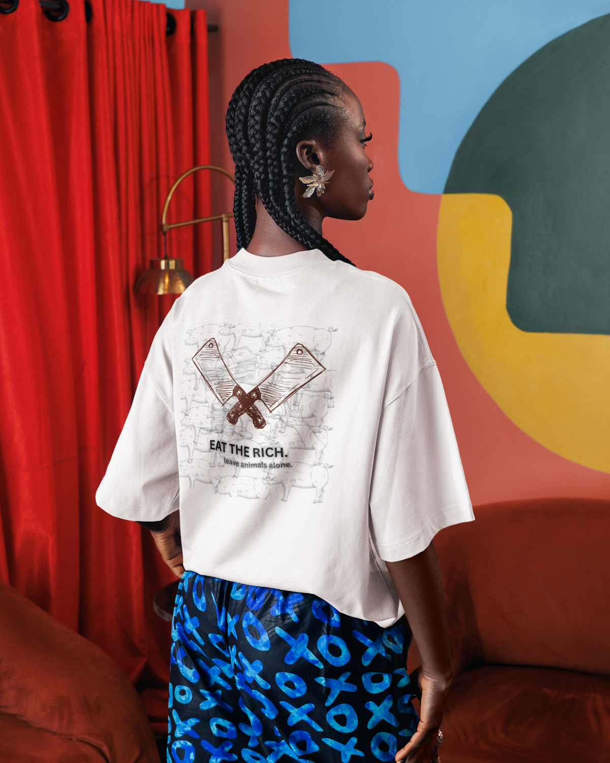 Frau mit einem oversized, weißen T-Shirt mit dem Aufdruck: "Eat the rich. Leave animals alone."