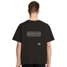 Person mit schwarzem, oversized T-Shirt mit dem Rückaufdruck:"Hör auf Tiere zu essen" in arabischer Sprache.