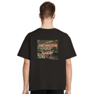 Person trägt schwarzes T-Shirt oversized mit dem Backprint: "The chicken are not alright. Stop eating them." Im Hintergrund des Schriftzugs ist ein Bild von Hühnern, zusammengedrängt auf engem Raum.