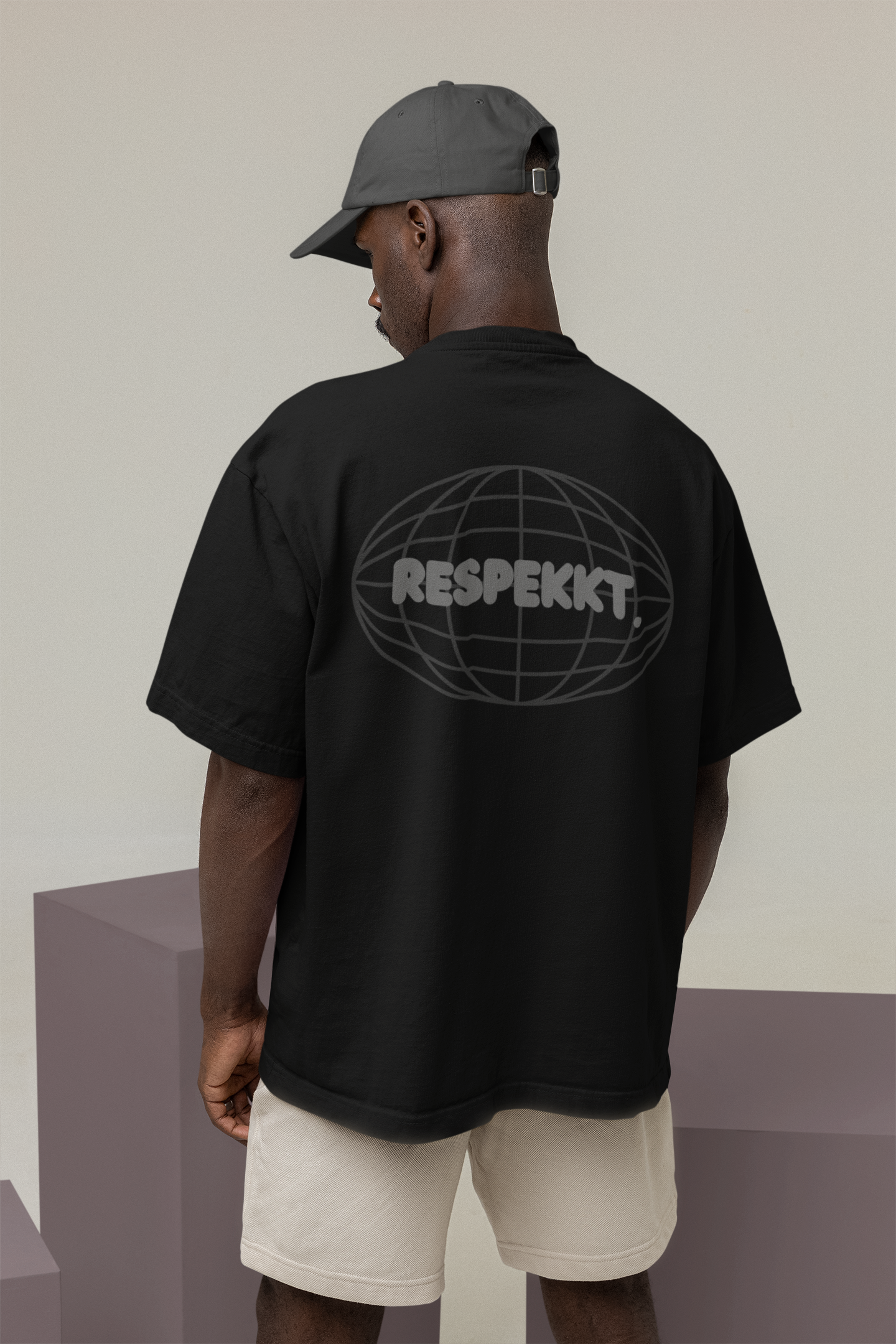 Mann mit schwarzem Oversized T-Shirt auf dem das Logo von der Marke Respekkt. aufgedruckt ist.
