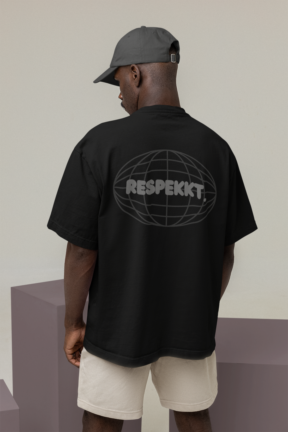Mann mit schwarzem Oversized T-Shirt auf dem das Logo von der Marke Respekkt. aufgedruckt ist.
